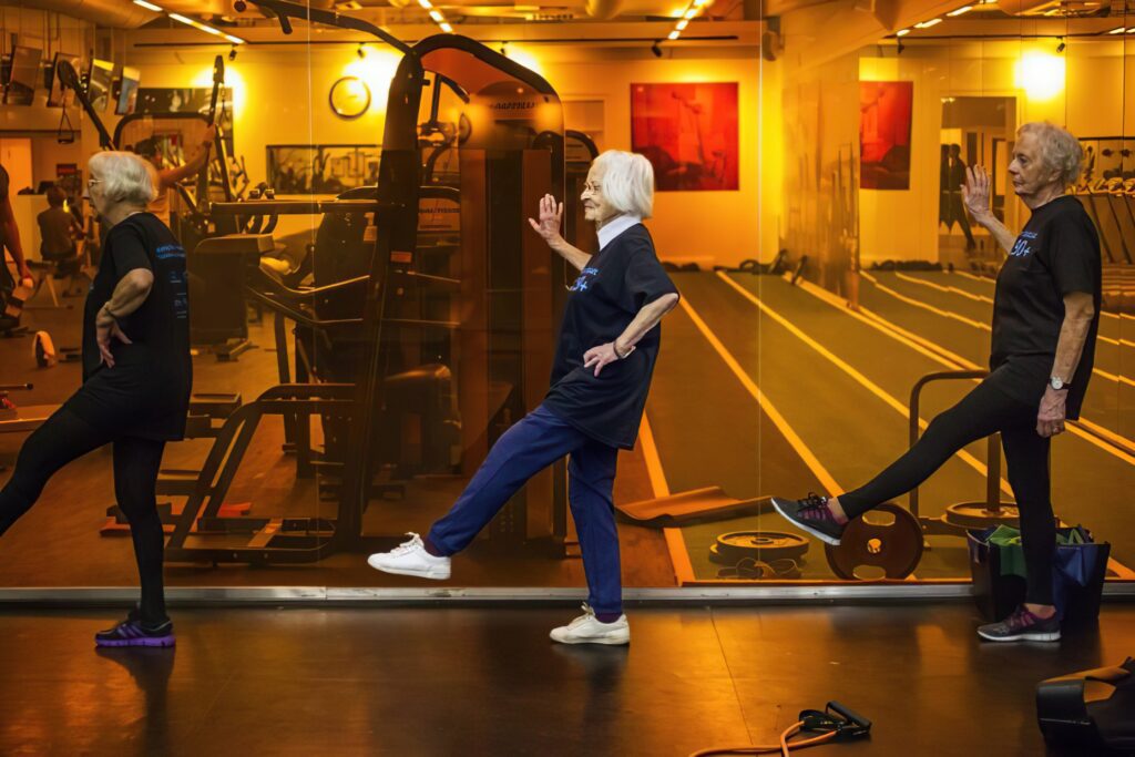 Tre äldre damer tränar balans.